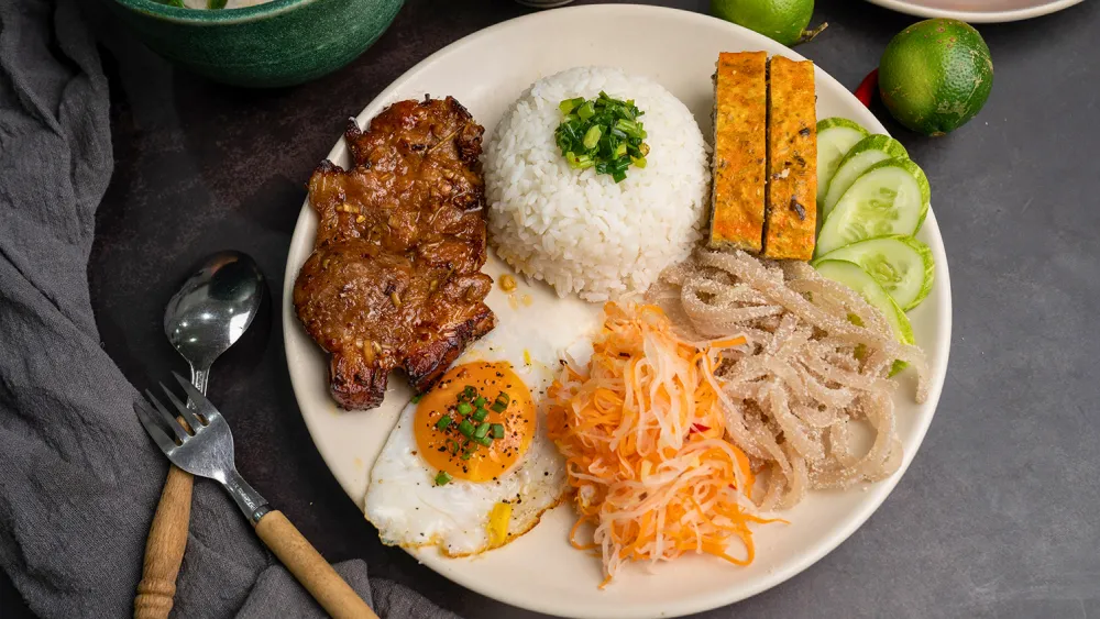 Đĩa cơm sườn bì chả hoàn chỉnh với cơm tấm, sườn nướng, bì, chả, trứng ốp la và đồ chua