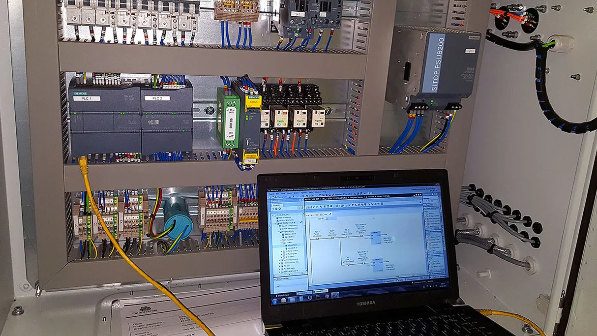 Kỹ sư thực hiện đấu nối dây tín hiệu vào module PLC trong quá trình kiểm tra hệ thống